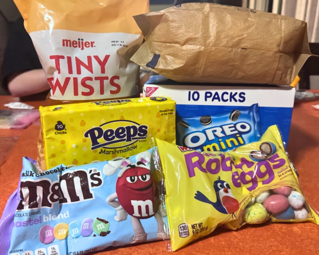 Ingredients for Easter snack mix including popcorn, Peeps, mini Oreos, pastel M&Ms, and Robin Eggs candy